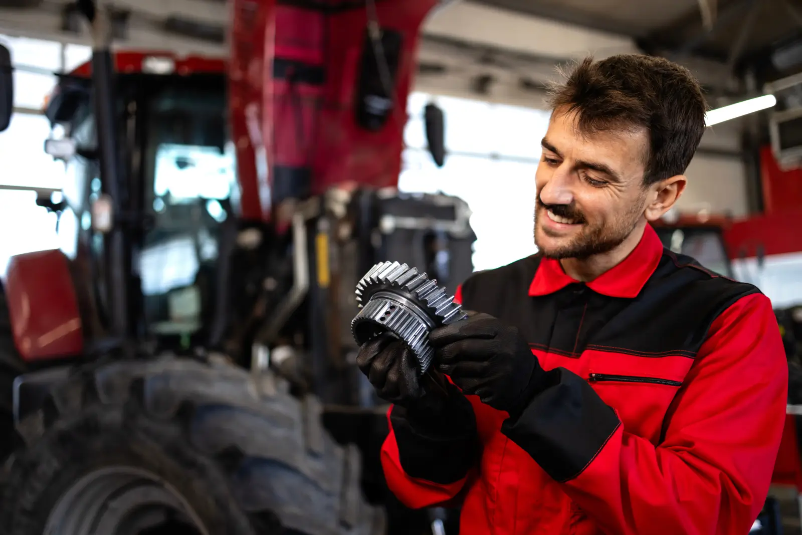 Service Department Employee Serving Tractor In Shop